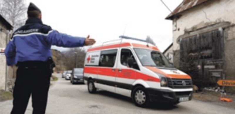 Un gendarme guía a una ambulancia de la Cruz Roja francesa en la zona. / Efe