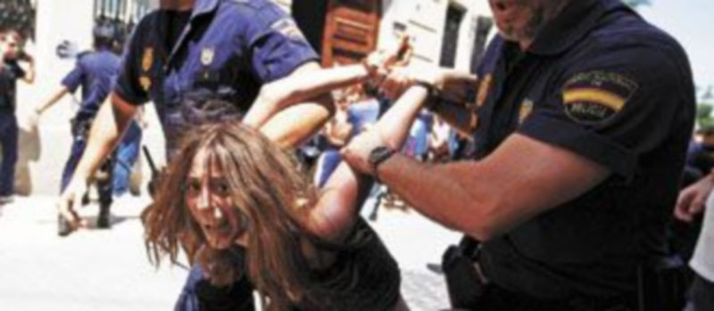 Dos agentes arrestan a una de las cientos de personas que se congregaron ante las puertas de ‘Les Corts’. / Efe