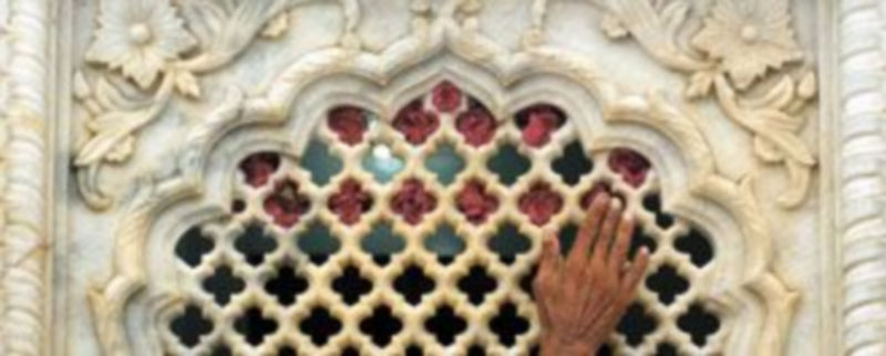 Un hombre adorna con rosas una ventana del templo sufí atacado el jueves por radicales sunitas en la ciudad paquistaní de Lahore. / Reuters