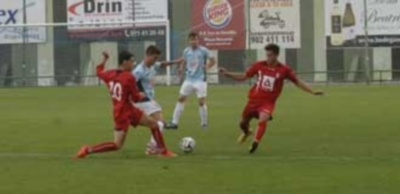El jugador gimnástico Manu conduce el balón por el centro del campo ante la presencia de dos rivales madrileños. / E. Peña