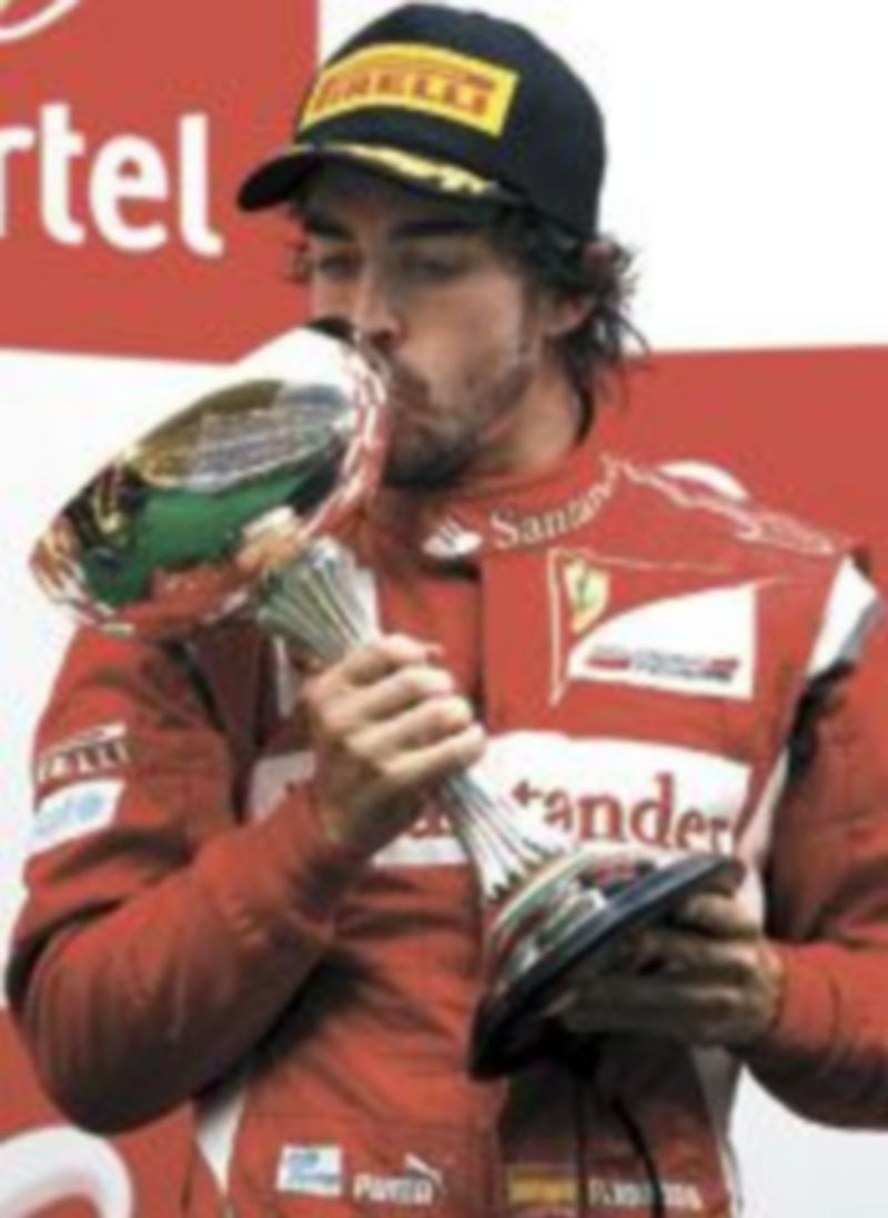 Alonso besa el trofeo conquistado en el trazado asiático. / Reuters