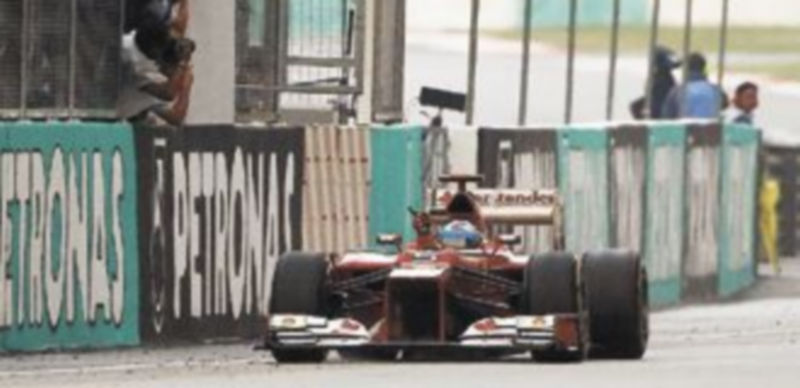 El piloto español de Ferrari cruza la línea de meta del Gran Premio de Malasia en primer lugar ante la alegría desbordada de todos los miembros de la escudería de ‘Il Cavallino Rampante’. / Tim Chong