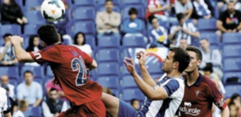 Stuani pelea un balón con el osasunista Damiá en un lance del partido. / T. Garriga (Efe)
