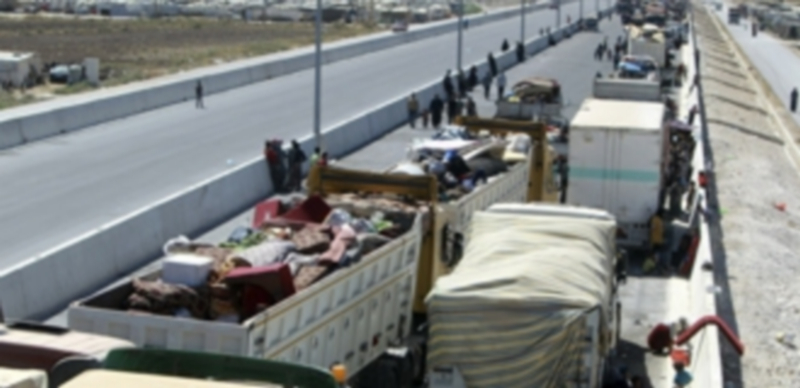 Varios refugiados sirios esperan junto a sus pertenencias en la población de Masnaa