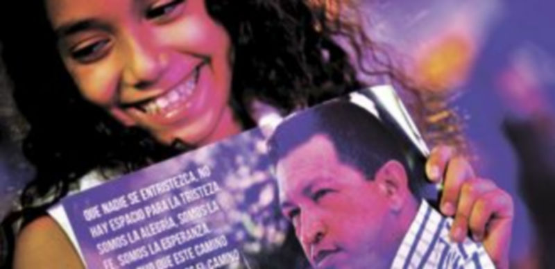 Una joven sostiene un cartel de ánimo al jefe del Ejecutivo de Venezuela. / Afp