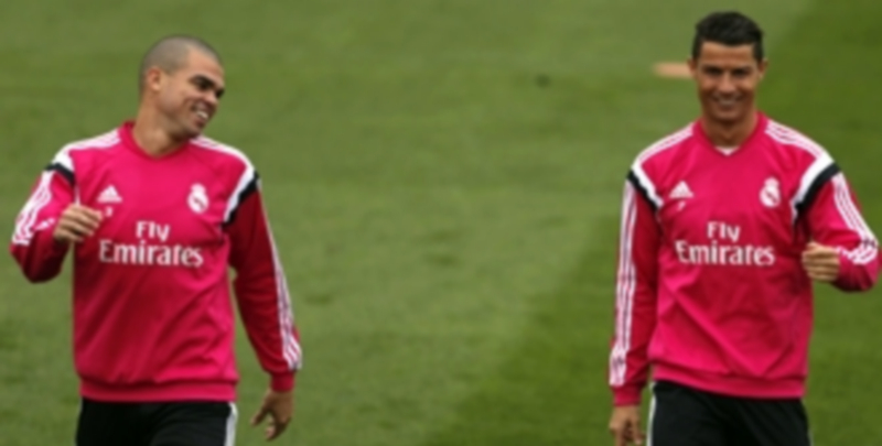 Los madridistas Pepe (i) y Cristiano Ronaldo ríen durante el entrenamiento de ayer para la preparación del partido. / EFE