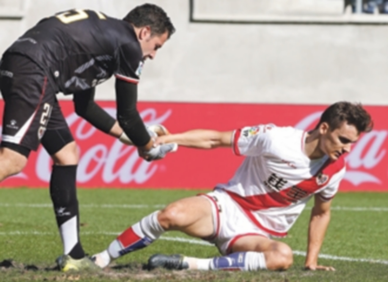 El cancerbero rayista Toño ayuda a levantarse a su defensor Diego Llorente