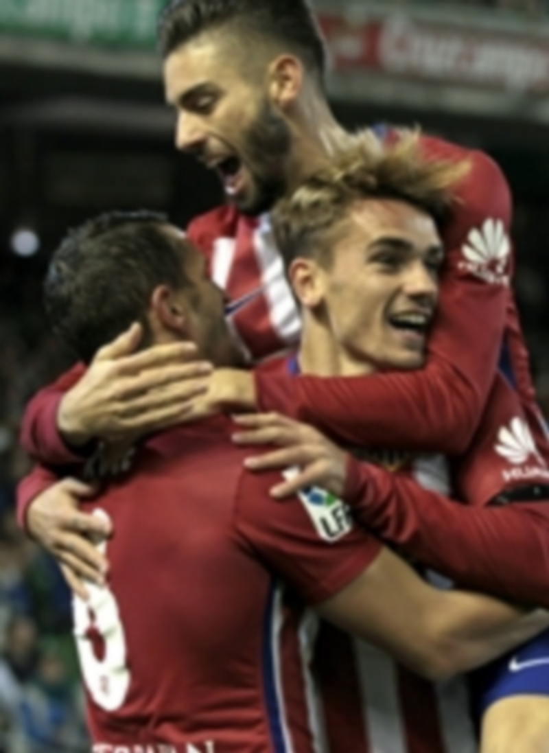 Carrasco y Griezmann (en el centro) felicitan a Koke tras el gol que dio los tres puntos al Atlético en el Benito Villamarín. / EFE