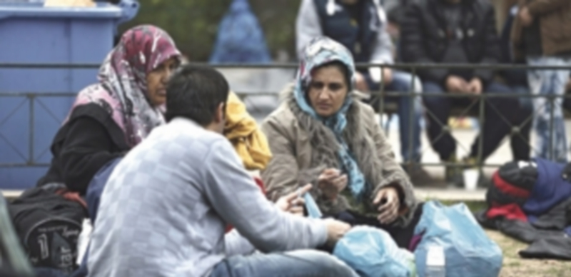 Inmigrantes afganos permanecen en una plaza ante la estación de metro Victoria en la capital griega
