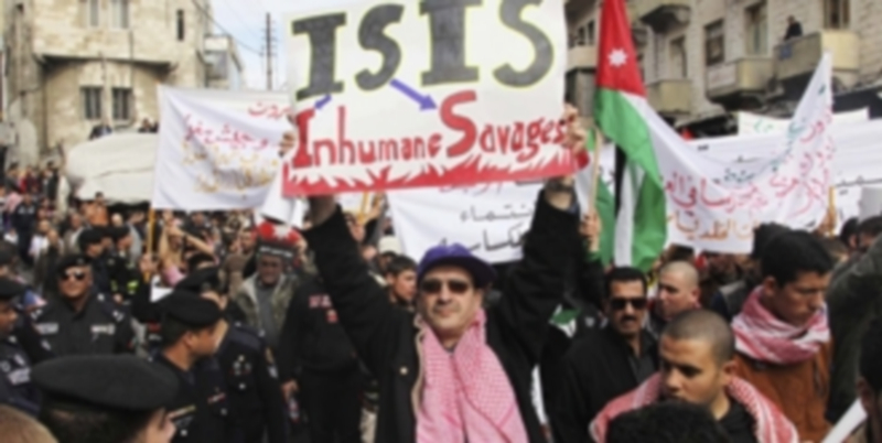 Un hombre sostiene un cartel criticando al Estado Islámico durante una protesta en Jordania por el piloto asesinado. / Efe