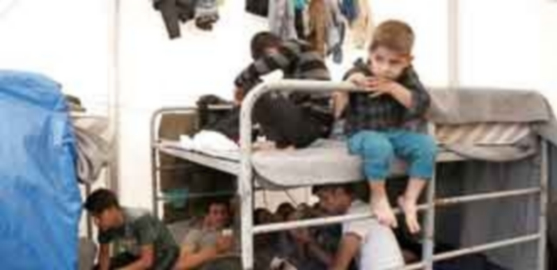 Una familia afgana encuentra refugio dentro de una tienda del campamento de tránsito situado al oeste de Atenas. / Efe