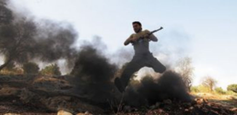 Un miliciano rebelde toma posiciones después de un ataque aéreo de las fuerzas del régimen de Al Asad. / Reuters