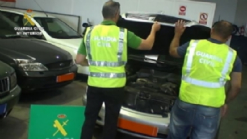 Dos agentes de la Guardia Civil inspeccionan uno de los coches comprados en la Unión Europea sin pagar el IVA correspondiente en España. / Europa Press