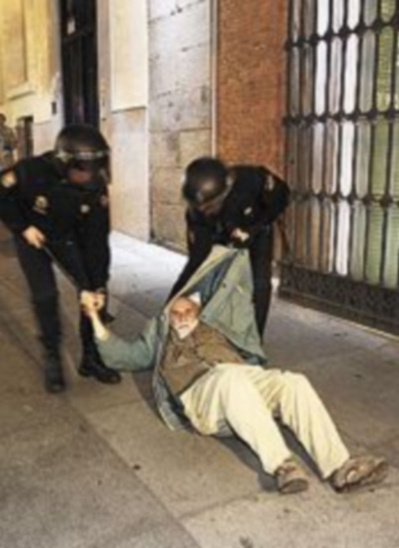 Dos policías desalojan a un hombre.