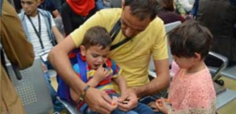 Refugiados sirios esperan tras su llegada al aeropuerto de Fiumincino en Roma