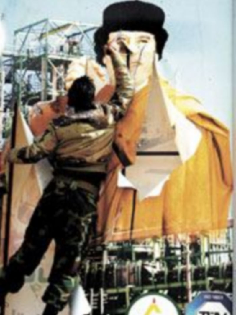 Un rebelde libio rompe una valla publicitaria con la imagen del coronel Gadafi en Ras Lanuf. / Efe