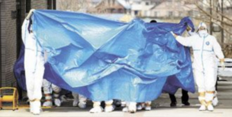 Trabajadores de la central japonesa trasladan a varios compañeros que han recibido altas dosis de radiación. / Kyodo (Reuters)