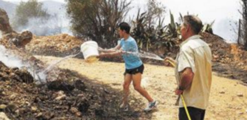 Los vecinos del municipio de Montroi luchan contra los rescoldos con todos los medios a su alcance. / Reuters