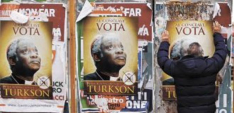 Un hombre coloca carteles propagandísticos en favor de uno de los aspirantes africanos a ser Obispo de Roma. / Reuters