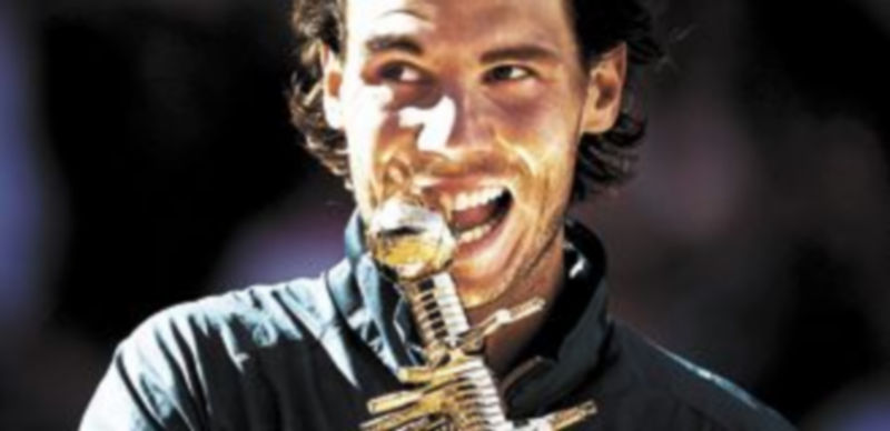 El balear muerde el trofeo conquistado en la Caja Mágica. / E. Naranjo (Efe)