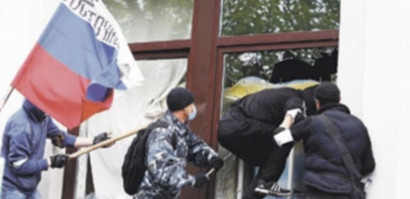 Un grupo de manifestantes accede al edificio gubernamental rompiendo una ventana y portando una bandera rusa. / Reuters