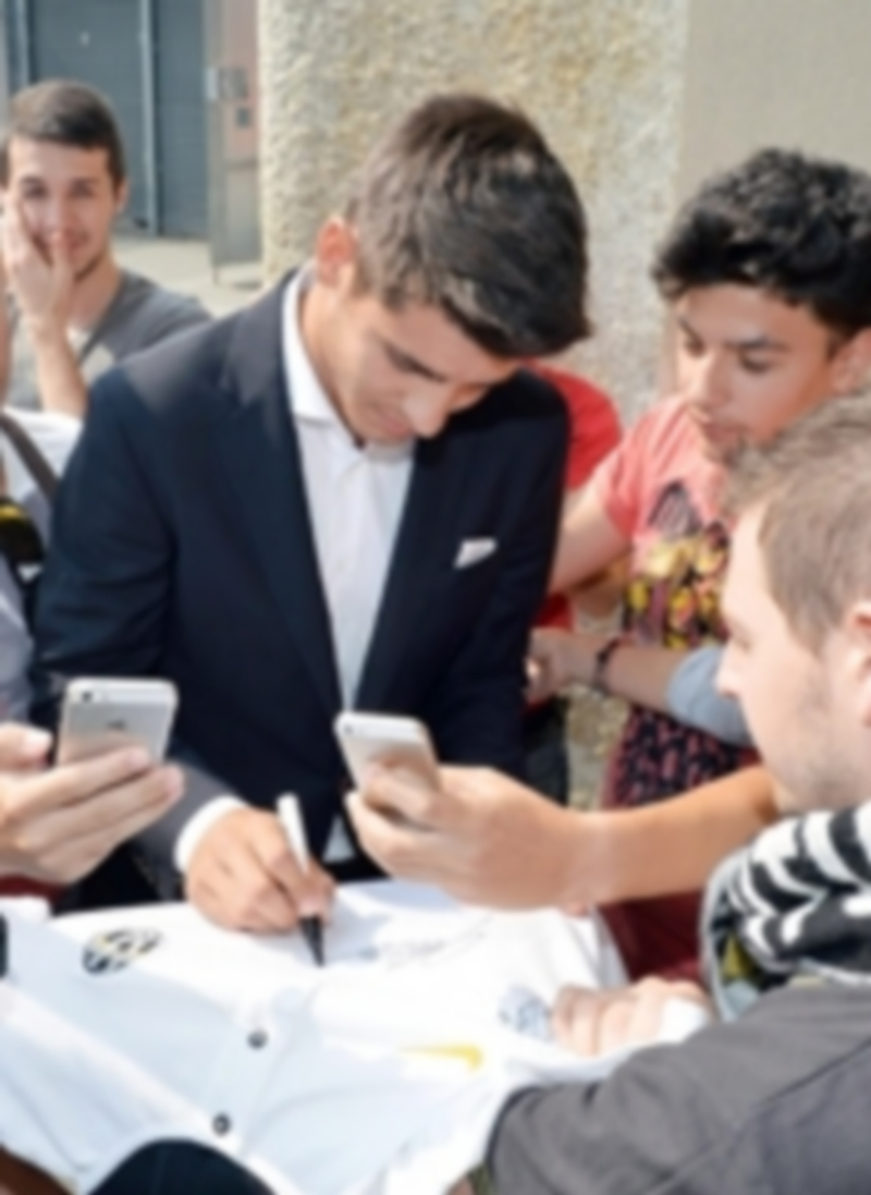 Morata firma una camiseta de la Juventus a su llegada a Turín. / Efe