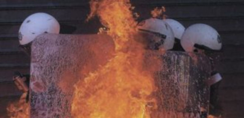 Un grupo de policías se ve cercado por el fuego encendido por los manifestantes más radicales. / Reuters