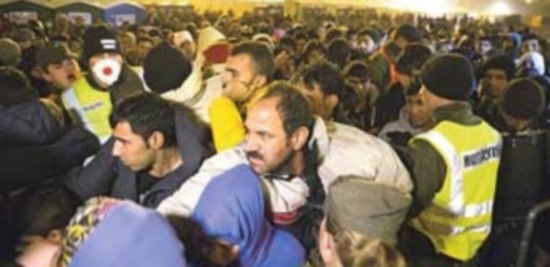 Un grupo de refugiados aguardan para ser llevados a un campo en la frontera entre Eslovenia y Austria. / EFE