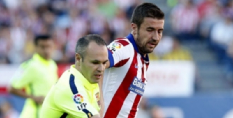 Andrés Iniesta (izq) controla el balón durante el partido ante el Atlético. / EFE
