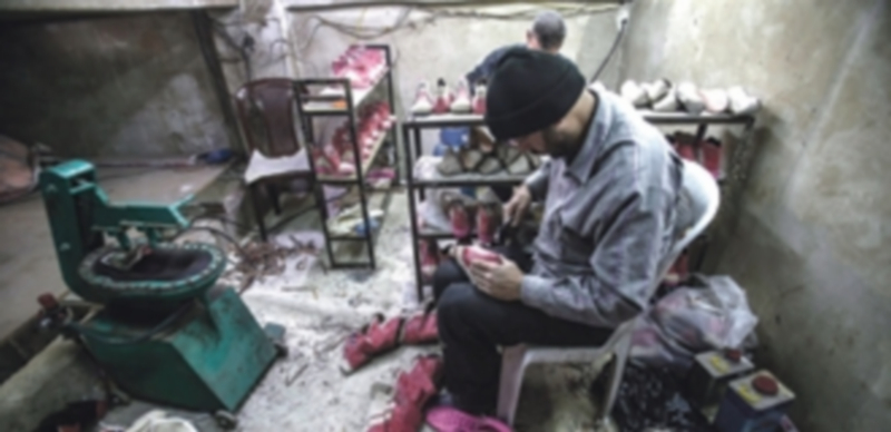 Un hombre confecciona zapatos para dárselos gratuitamente a los niños del barrio de Al-Qaboun