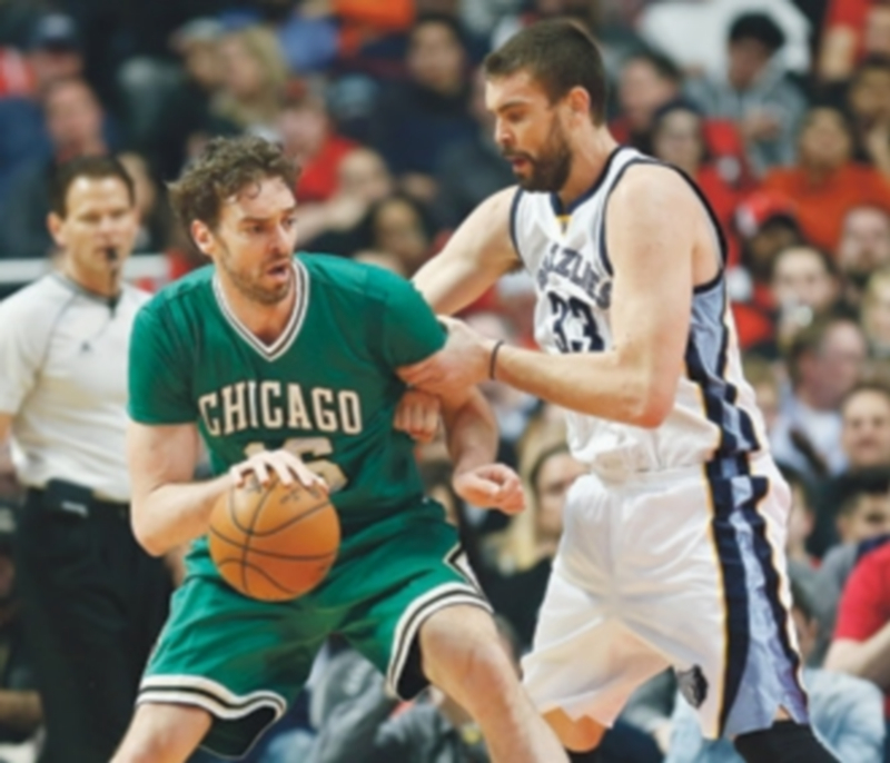 Pau Gasol protege el balón en el poste bajo ante la defensa de Marc. / EFE