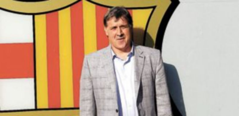 El argentino posó junto al escudo del club a su llegada al Camp Nou. / Efe