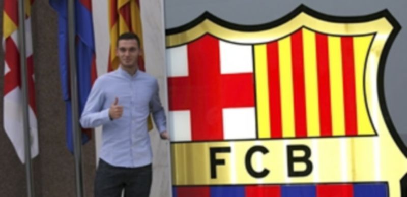 Vermaelen posa para los reporteros gráficos ante un gran escudo del FC Barcelona en los momentos previos a su presentación como nuevo jugador. / Efe