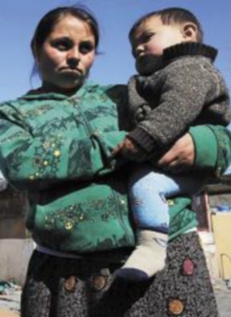 Un mujer de raza gitana sostiene a su hijo en brazos. / Susana Vera