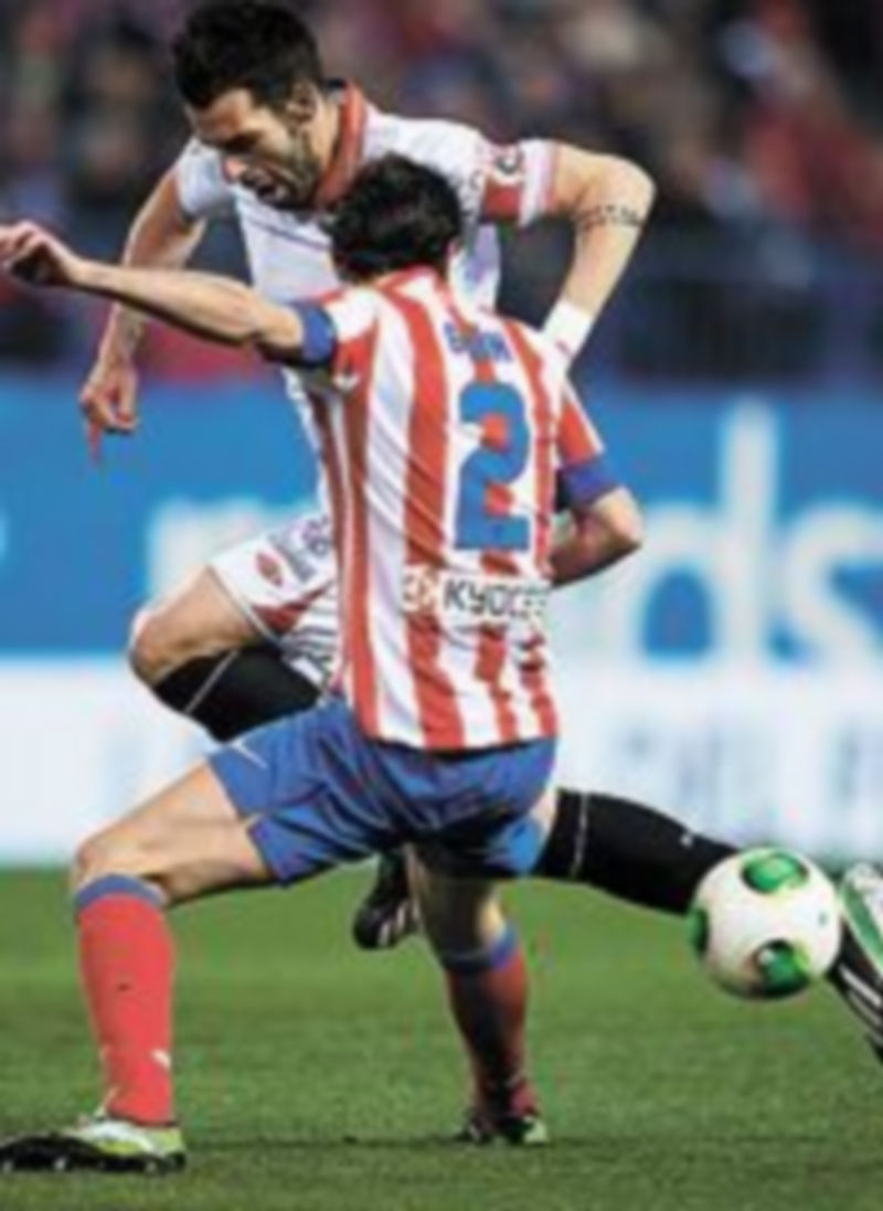 Negredo intenta llevarse al esférico ante Godín. / AFP