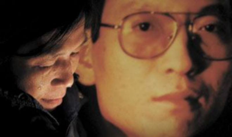 Una activista llora junto a una foto del disidente chino Liu Xiaobo