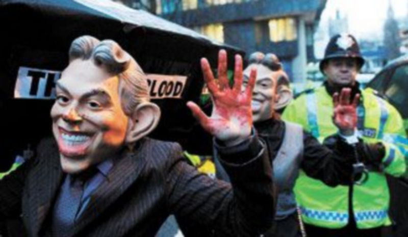 Manifestantes disfrazados de Blair son escoltados por la Policía frente al lugar de Londres donde se celebra la comisión sobre la invasión de Iraq. / EFE