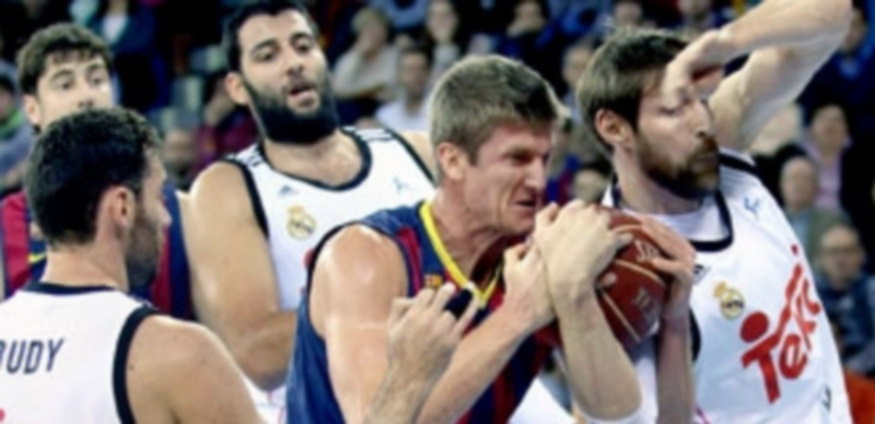 El ala pivot estadounidense del Barcelona Justin Doellman (c) lucha por el rebote con el ala pivot argentino del Real Madrid Andrés Nocioni