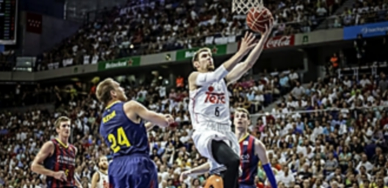 El ala-pívot madridista Andrés Nocioni se eleva con el balón para anotar ante la pasividad de la defensa barcelonista. / EFE