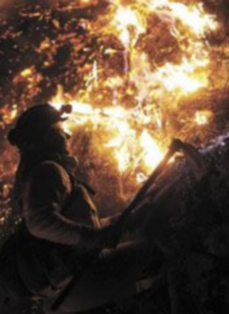 Un bombero intenta sofocar las llamas de un incendio. / Reuters