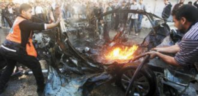 Varias personas intentan apagar el fuego del coche en el que viajaban Yaabari y su acompañante