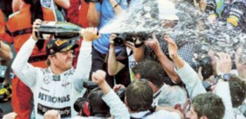 El piloto germano festejó su triunfo en las calles del Principado rociando con champán a los mecánicos de su equipo. / S. Suki (Efe)