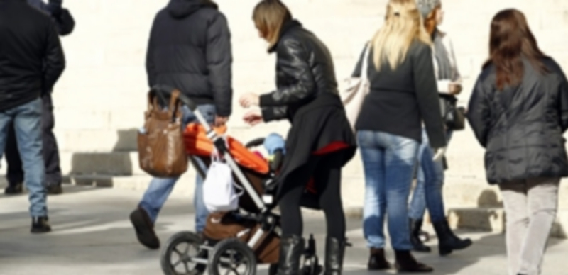 Un grupo de personas de distintas edades pertenecientes a la misma familia en una calle de una ciudad española. / EP