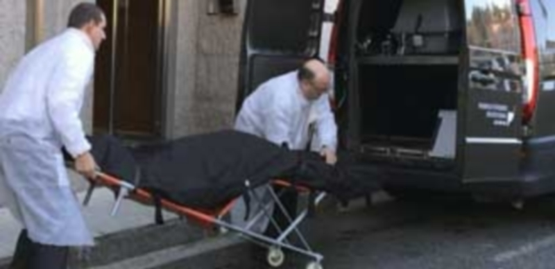 Efectivos de los servicios funerarios trasladan al hombre fallecido tras ser acuchillado por el exnovio de su pareja. / Efe