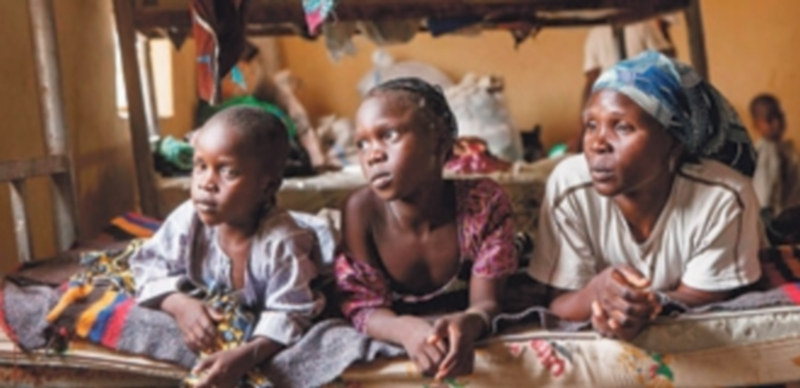 Una mujer y sus dos hijas en un campo de refugiados de Yola