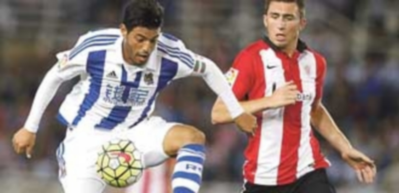 Carlos Vela controla el balón ante la presión de Aymeric Laporte