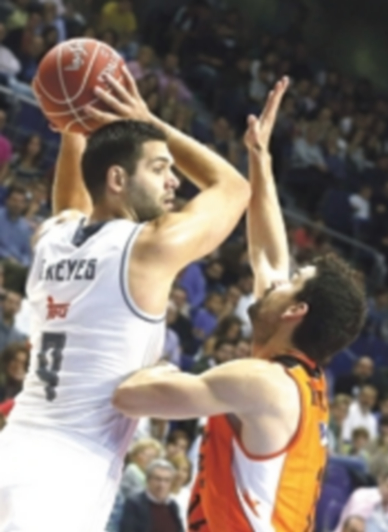 El pívot merengue Felipe Reyes (izq) intenta un pase ante Rafa Martínez. / EFE