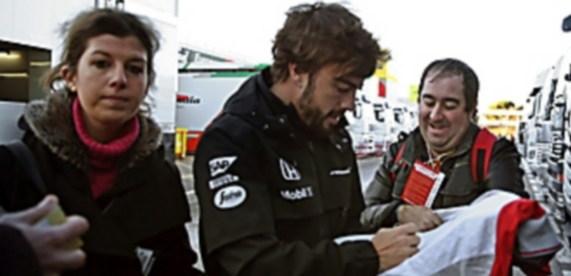 Alonso firma un autógrafo antes de tomar parte de los entrenamientos libres. / EFE