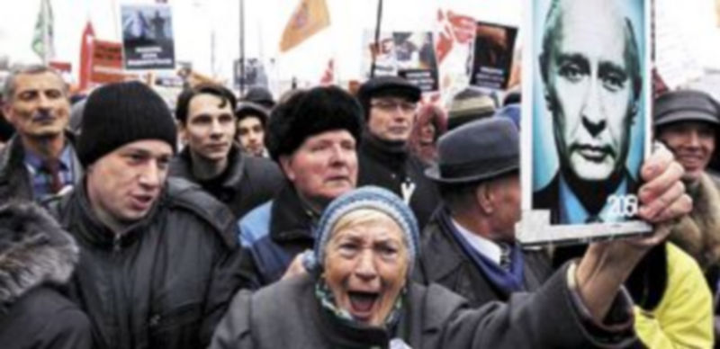 Una mujer sostiene una fotografía de Vladímir Putin durante la manifestación contra su Gobierno en Moscú. / Efe.