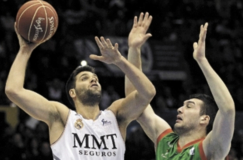 El ala-pívot del Real Madrid Felipe Reyes intenta encestar ante la oposición del alero georgiano del Cajasol Beka Burjanadze. / Efe